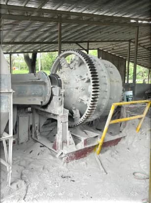 Molino industrial con engranaje y baranda de protección en la planta de ADN