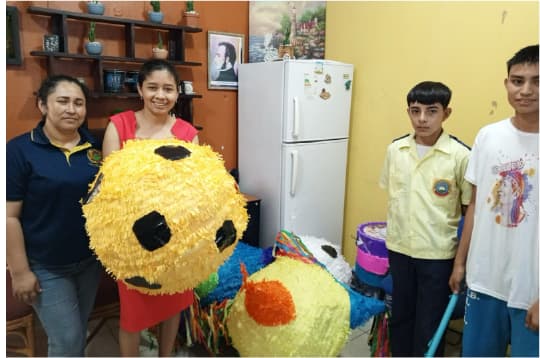 Participantes de una actividad comunitaria con piñatas elaboradas a mano